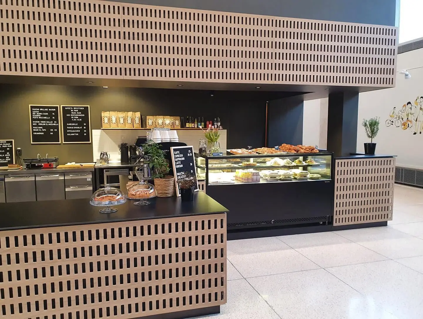 Caféinredning med måttanpassade bardiskar och perforerade träfronter runt serveringsytan
